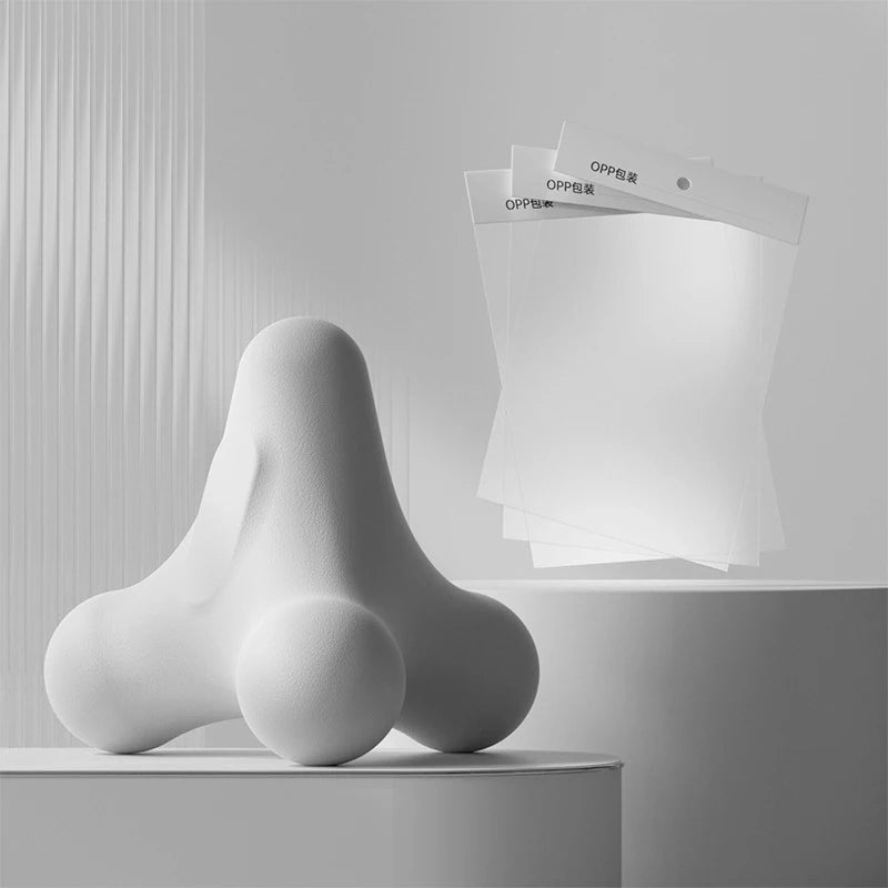 White ergonomic massage tool displayed with transparent OPP packaging bags in clean monochromatic layout